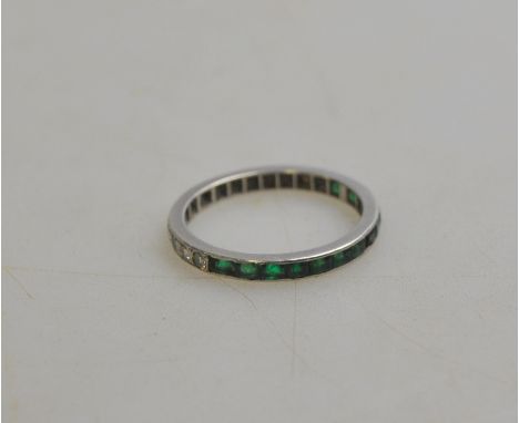 A full eternity ring, half set with brilliant cut diamonds, the other half set with baguette cut emeralds, with plain sides, 