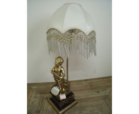 Decorative table lamp with figure of a cherub on stepped square base, the shade with dropped glass pendants 