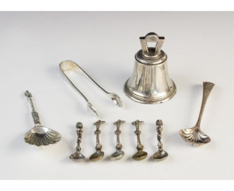 A George V silver bell by Goldsmiths & Silversmiths Co, London 1934, 6.4cm high, together with a set of three unusual white m