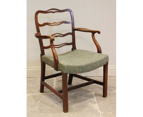 A George III Chippendale style elm elbow chair, with four pierced rugs extending to out swept arms with carved paper scroll t