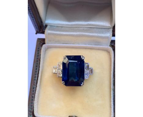 An Art Deco sapphire and diamond ring, the central rectangular emerald cut Burmese sapphire (measuring 12.12mm x 8.81mm x 5.2