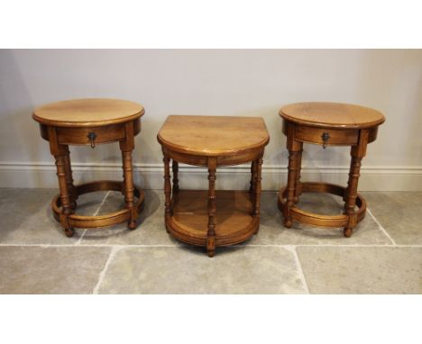 A pair of reproduction golden oak lamp tables, late 20th century, each with a circular moulded top above a single frieze draw