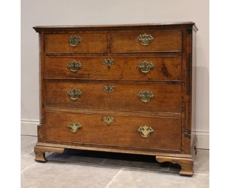 A George III oak chest of drawers, with an arrangement of two short and three long graduated drawers, flanked by quarter pila
