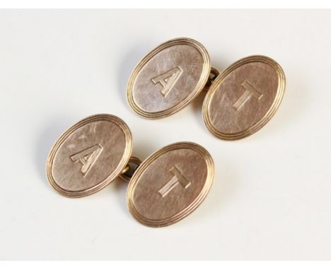 A pair of 9ct gold cufflinks, the oval panels with engine turned reeded borders engraved with initials 'A' and 'T', each pane