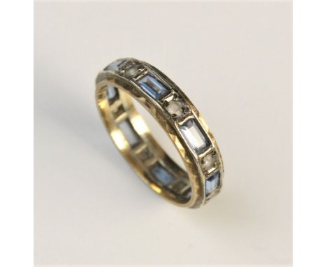 A sapphire set eternity ring, set with alternating blue and white coloured stones in yellow and white 9ct gold, size O, weigh