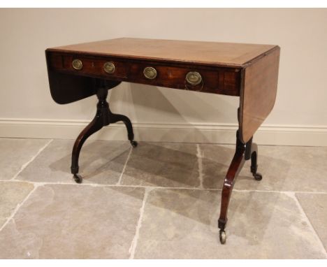 An early 19th century mahogany sofa table, the rectangular top above two drawers, terminating with two drop leaves and upon a