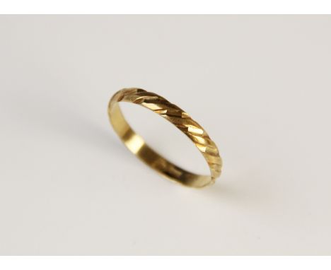 A yellow metal ring, with engraved twist detail, stamped '750', size X, weight 2.2gms