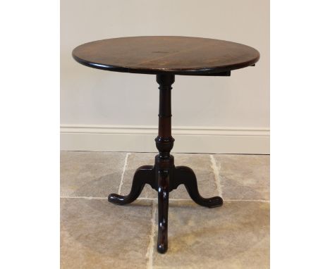 A George III mahogany tripod table, the circular top on a ring turned gun barrel pedestal extending to three cabriole down-sw