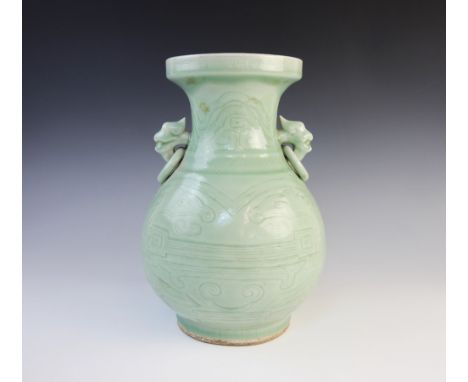 A Chinese celadon glazed baluster vase in the Yuan Dynasty style, with incised archaic decoration, ring handle lugs, below a 