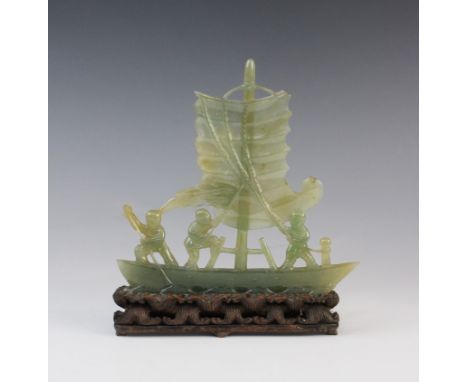 A Chinese celadon jade carving of a boat, 19th/20th century, the boat carved with a sail attached to ropes, with three figure