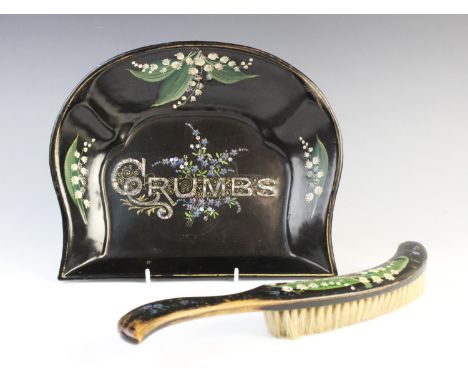 A Victorian ebonised and painted crumb tray and brush, the metal crumb tray painted with lily of the valley, centred with mot