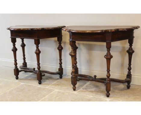 A near pair of William and Mary walnut console side tables, the shaped serpentine, demi-lune top raised on four turned legs u