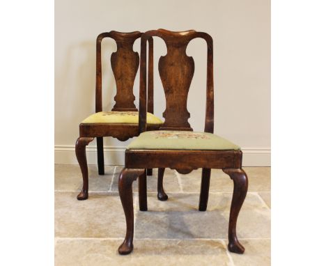 A pair of Queen Anne walnut side chairs, each with a vase shaped splat over a tapestry drop in seat, raised upon cabriole fro