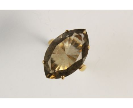 A smokey quartz dress ring, the mixed cut marquise shaped smokey quartz (measuring 25mm x 10mm), claw set to a pierced design