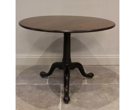 A George III mahogany tripod table, the circular top with a moulded edge, raised on a cylindrical ring-turned column on three