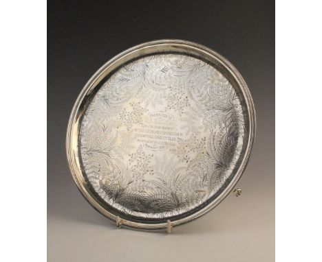 A Victorian silver salver by James Dixon &amp; Sons, Sheffield 1877, of circular form on three paw feet, elaborately engraved