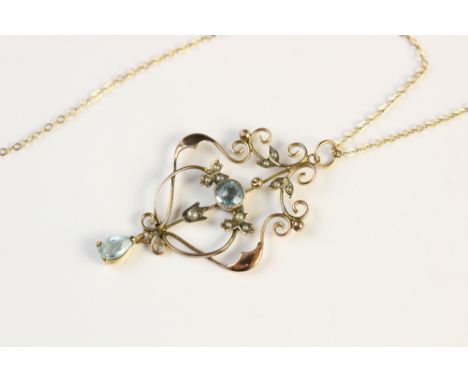 An Edwardian 9ct gold pendant, set with blue paste and simulated pearls to a scrolling wirework frame, set to a yellow metal 