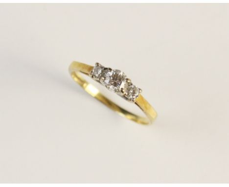 A diamond three stone ring, comprising a central round brilliant cut diamond (weighing between 0.20 - 0.25 carats), with a fu