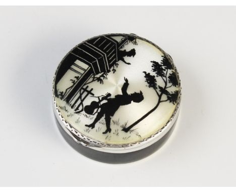 A silver and enamel pill box, import marks for Cohen & Charles, London 1926, of circular form, decorated with black and cream