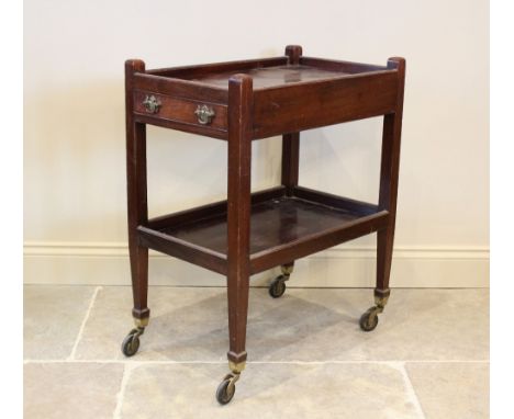 An early 20th century mahogany tea trolley, the upper galleried tray with a single frieze drawer opposed by a faux drawer, ra