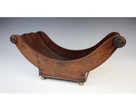 A Regency mahogany cheese coaster, of curved form applied with turned baluster half pilasters, raised upon brass castors, 40c