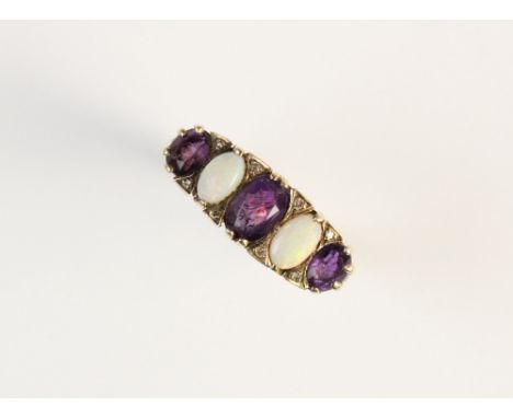 An amethyst and opal 9ct gold dress ring, comprising three oval mixed cut amethysts measuring between 4mm x 5mm and 5mm x 7mm