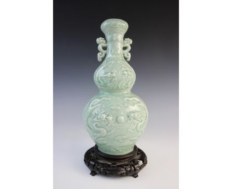 A 19th century Chinese celadon glazed gourd vase, decorated in relief depicting two scrolling dragons and a flaming pearl, ar