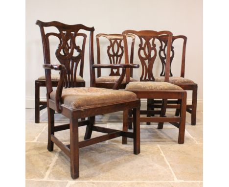 A matched set of five elm and oak George III Chippendale style dining chairs, each with an interlaced open work splat back, a