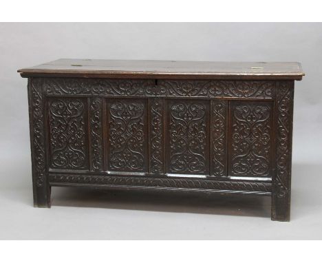 OAK COFFER, 17th century, the hinged lid in two sections and with pin hinges above a scrolling foliate top rail and four pane
