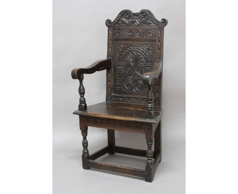 ENGLISH JOINED OAK WAINSCOT OR ARM CHAIR, mid 17th century, the scrolling crest rail carved IH and the date 1674, above a sin