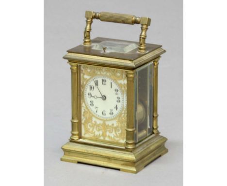 FRENCH GILT BRASS FOUR PANE CARRIAGE CLOCK, the ivorine dial inside a scrolling gilt frame on a brass, eight day, half hourly