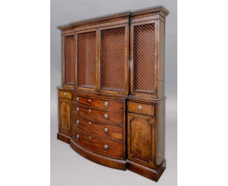 GEORGE III STYLE MAHOGANY BREAKFRONT BOOKCASE, the dentil cornice above four grille doors enclosing adjustable shelving on a 