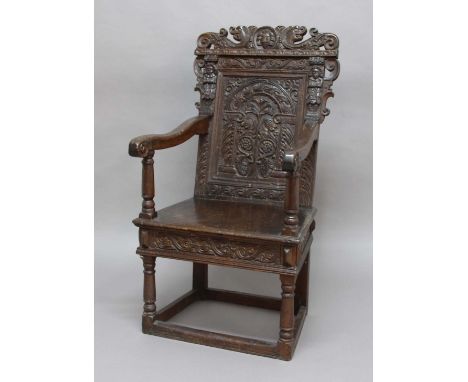 ENGLISH JOINED OAK WAINSCOT OR ARM CHAIR, early or mid 17th century, the crest rail centred by a male mask flanked by scrolli