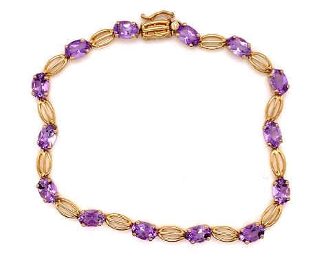 A 9ct HALLMARKED  GOLD AND AMETHYST BRACELET. THE FOURTEEN OVAL FACET CUT AMETHYSTS EACH IN A FOUR CLAW SETTING, INTERSPERSED
