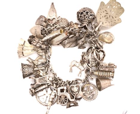 A VINTAGE SILVER CHARM BRACELET COMPLETE WITH PADLOCK CLASP AND ATTACHED SAFETY CHAIN, CHARMS TO INCLUDE A BEEHIVE WITH OPENI