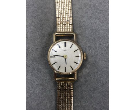 A 9ct GOLD TISSOT LADIES WRIST WATCH ON A BRICK STYLE STRAP WITH LADDER CLASP GROSS WEIGHT 21.2 grms