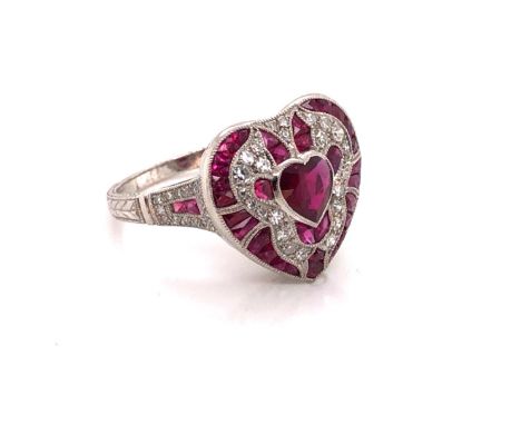 A RUBY, DIAMOND AND PRECIOUS WHITE METAL STAMPED PLAT AND ASSESSED AS 950 PLATINUM FINENESS ART DECO STYLE HEART SHAPED RING.