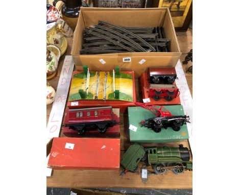 A HORNBY 0 GUAGE CLOCK WORK LOCOMOTIVE, TENDER, ROLLING STOCK, RAIL AND A LEVEL CROSSING