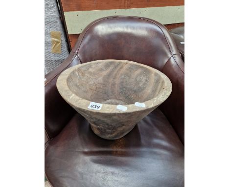 A BOWL CARVED FROM A TREE TRUNK SECTION