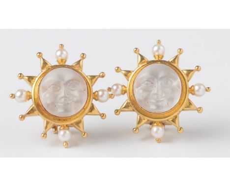 Elizabeth Locke, a pair of earrings with carved opaque glass moon faces, the yellow metal mounts set with a sunray border wit