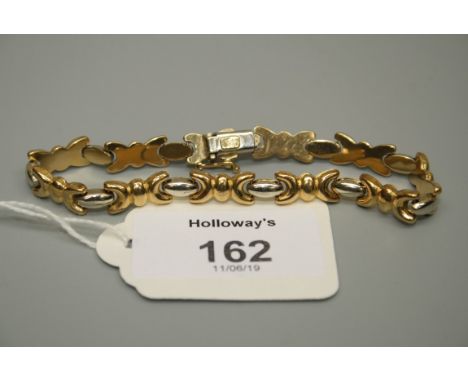 A bi-coloured bracelet of fancy bow design with oval spacers to concealed push button clasp, stamped Italy '750' 12.9g