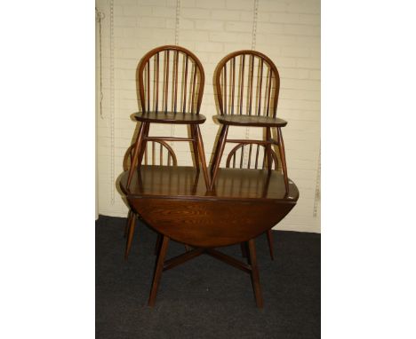 An Ercol drop flap dining table and a set of four hoop and stick back dining chairs