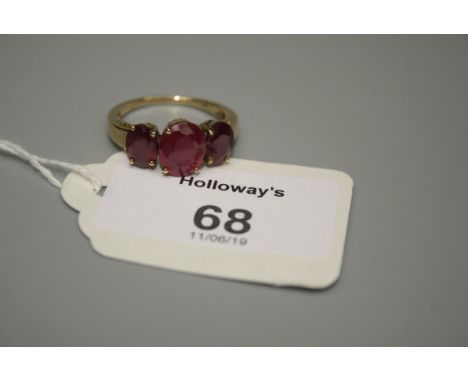 A three stone half hoop ruby ring, the graduated oval cut rubies in plain 9ct gold mount 3.9g