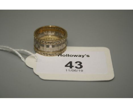 A two colour diamond set ring, the engine turned band within stone borders, marked 585, 5.02g