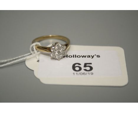 A seven stone diamond cluster ring, the brilliant cut diamonds in 18ct gold claw mounted snowflake design