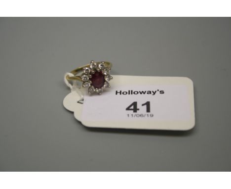 A ruby and diamond cluster ring, the oval cut ruby within a brilliant cut diamond border, claw set throughout to plain shank.