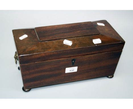 A Victorian mahogany sarcophagus form tea caddy with twin lidded interior and provision for bowl on bun feet