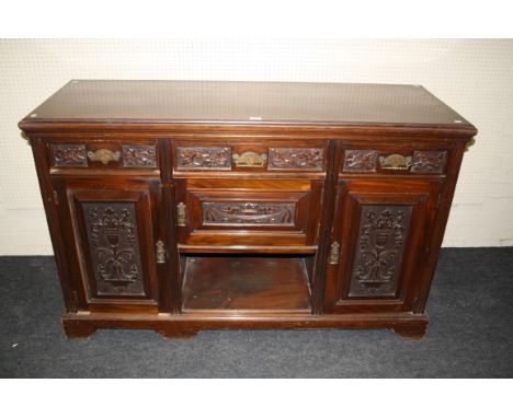 An Edwardian mahogany dresser with carved frieze drawers and cupboards around 'dog kennel' recess, on bracket plinth, 96 x 14