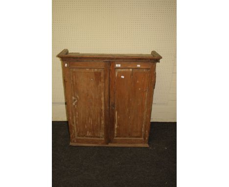 A 19th century pine wall cupboard with a pair of fielded panel doors enclosing shelf provision over four drawers, a project. 