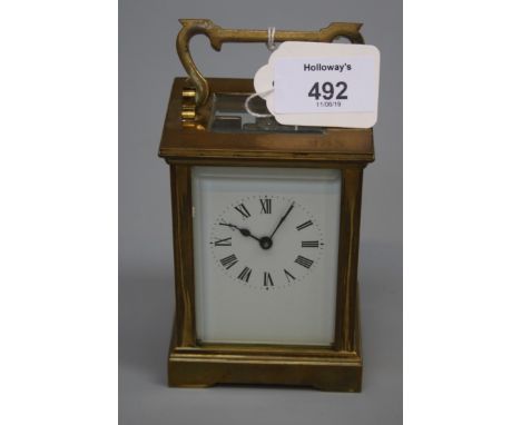 A mid 20th century brass carriage timepiece with eight day movement and enamel Roman dial. 15.5cm (handle up)